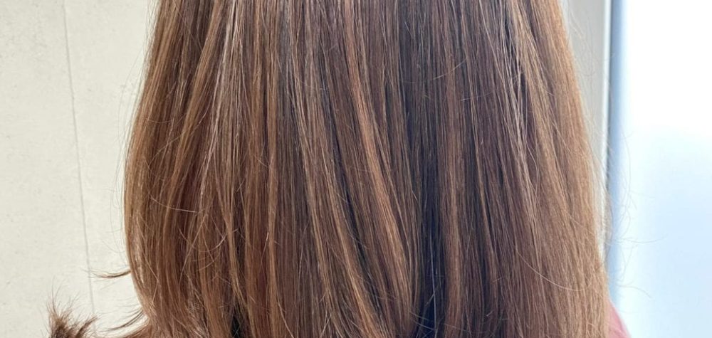Hinterkopf einer Frau mit glatten brÃ¼netten Haaren und die nach unten heller werden